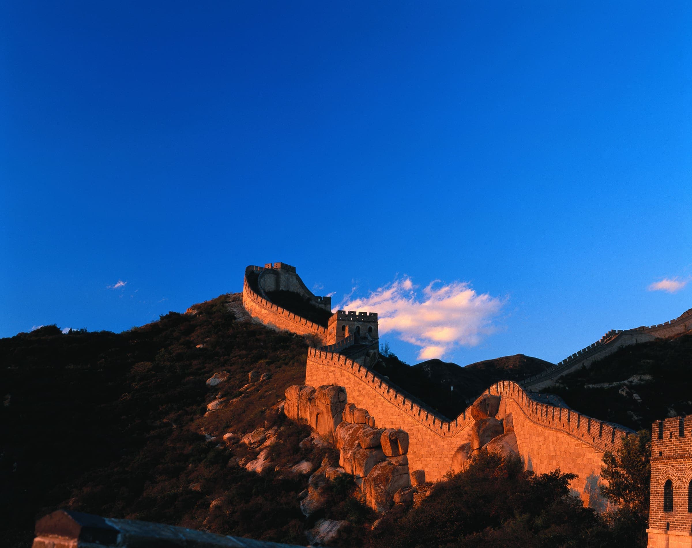 The Great Wall following a ridge outside Beijing, lit gold by a low sun
